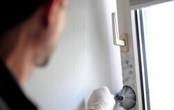 Ein Kriminaltechniker sichert Fingerabdrücke an einem Fenster. Foto: Julian Stratenschulte/Symbol