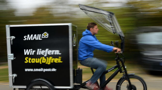 Mitarbeiter Benjamin Plangger von S-Mail/GEA Post-Service in Reutlingen auf dem neuen Elektro-Lastenrad. FOTO: NIETHAMMER