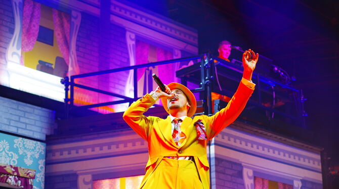 Leuchtendes Fantasie-Outfit, pittoreske Hotel-Kulisse: Rapper Alligatoah beim Auftritt in der Schleyerhalle. FOTO: BECKER Leuchtendes Fantasie-Outfit, pittoreske Hotel-Kulisse: Rapper Alligatoah beim Auftritt in der Schleyerhalle. FOTO: BECKER