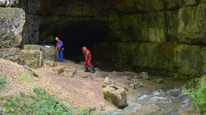 Zwei Höhlenretter vor dem mächtigen Portal der Falkensteiner Höhle unterhalb von Grabenstetten, in der ein Höhlenführer und sein Zwei Höhlenretter vor dem mächtigen Portal der Falkensteiner Höhle unterhalb von Grabenstetten, in der ein Höhlenführer und sein