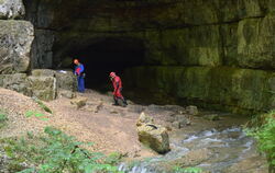 Zwei Höhlenretter vor dem mächtigen Portal der Falkensteiner Höhle unterhalb von Grabenstetten, in der ein Höhlenführer und sein