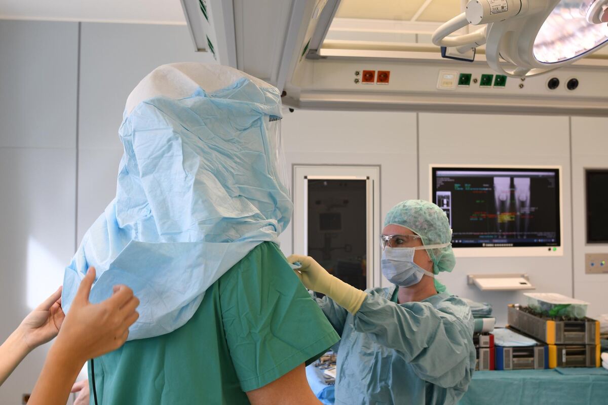 Anlegen der sterilen Hauben vor der Operation. Anlegen der sterilen Hauben vor der Operation.