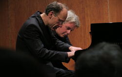 Zur Zugabe mit Ravel nehmen sie an einer Tastatur Platz: Andreas Grau und Götz Schumacher in gemeinsamer Konzentration beim Reut