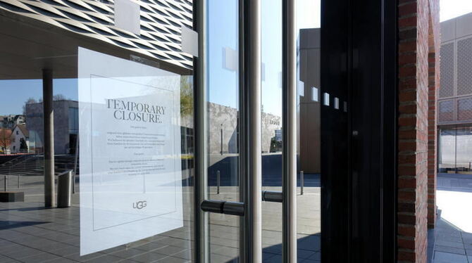»Temporary Closure« steht auf einem Zettel, der hinter der Glastüre eines Shops in der Outletcity hängt.