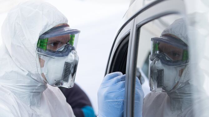 Im Drive-in wird mit einem Stäbchen ein Abstrich bei einem Autofahrer gemacht. FOTO: DPA