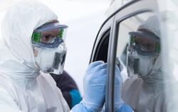 Im Drive-in wird mit einem Stäbchen ein Abstrich bei einem Autofahrer gemacht. FOTO: DPA