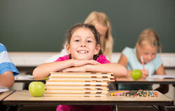 Eine strahlende Schülerin im Klassenzimmer.