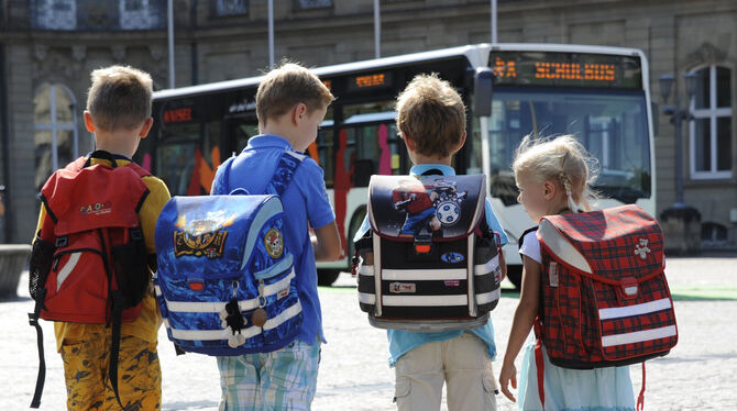 Grundschüler warten auf einen Bus.