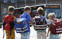 Grundschüler warten auf einen Bus.