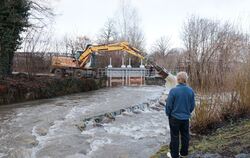 Hochwasser an der Erms am Metzinger Freibad. Ein Bagger wird eingesetzt, um Treibholz zu beseitigen.