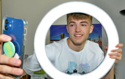 Influencer Lewinray filmt sich mit dem Handy durch ein Ringlicht.
