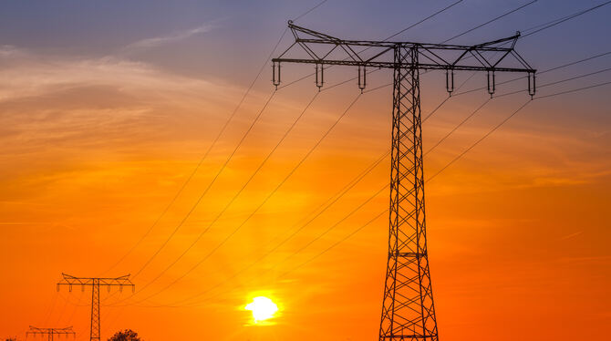 Ein Strommast steht in der Landschaft.