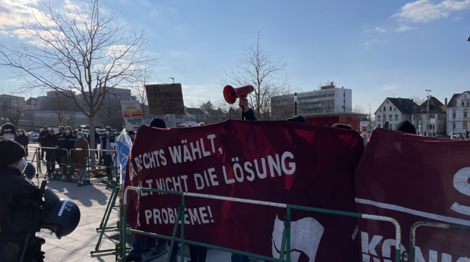 Mit einer elektronisch verstärkten Sirene stört ein Gegendemonstrant die Veranstaltung.