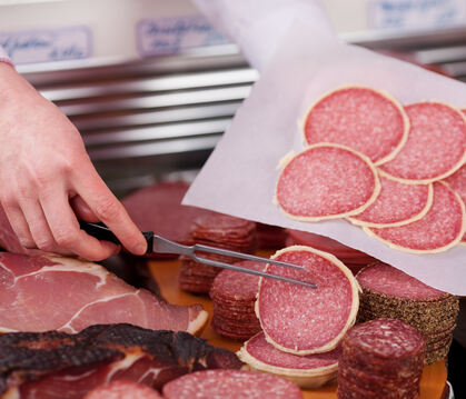metzgerei, wurst, salami, schinken, aufschnitt, scheiben, verkauf, verkaufen, metzger, theke, bedientheke, bedienen, wurstwaren, pfeffer, getrocknet, fleisch, fleischerei, qualität, frische, aufgeschnitten, geräuchert, schneiden, auswahl, rind, rindfleisc
