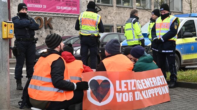 Freundlich begleitet von Polizisten sitzen Aktivisten der »Letzten Generation« am Montagmorgen auf einer Verkehrsinsel am Reutli