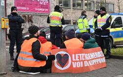 Freundlich begleitet von Polizisten sitzen Aktivisten der "Letzten Generation" am Montagmorgen auf einer Verkehrsinsel am Reutli