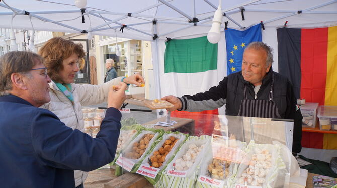 Naschen erlaubt – Walter Biancospino (rechts) verteilt kleine Leckereien an seine Gäste auf dem Toskanischen Markt in Reutlingen