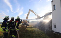 Die Engstinger Feuerwehr bekämpft den Brand. Ein Bagger reißt die von der Hitze verbogenen Stahlwände ein. 