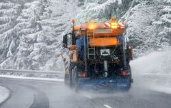 Ein Fahrzeug des Winterdiensts fährt durch eine verschneite Landschaft.