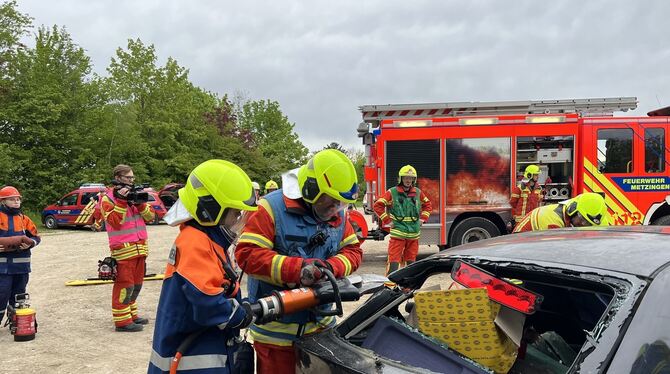 Mitglieder der Jugend- und der Erwachsenenfeuerwehr arbeiten Hand in Hand, hier mit der Rettungsschere, deren Einsatz Kraft und Mitglieder der Jugend- und der Erwachsenenfeuerwehr arbeiten Hand in Hand, hier mit der Rettungsschere, deren Einsatz Kraft und
