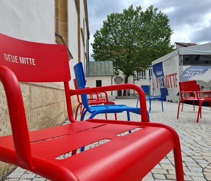 Bitte Platz nehmen: rote und blaue Stühle in Pfullingens Neuer Mitte laden zum Verweilen ein.