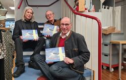 Verleger Wolfgang Wiedemann (links), Autor Reiner Frenz und Segelflug-Ikone Uli Schwenk (vorn) mit dem neuen Buch.   FOTO: SCHRA