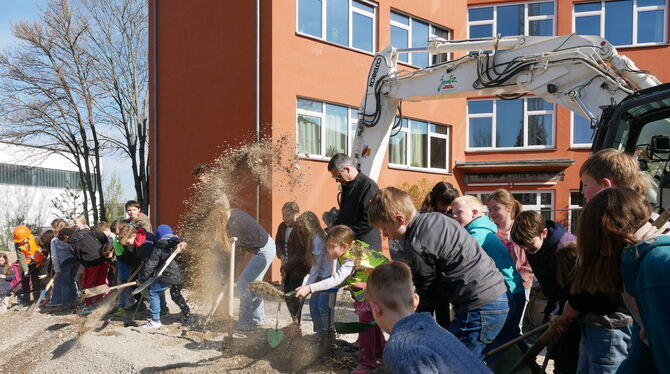 Gemeinsam mit Bauunternehmer Kay Jentz warfen Kinder und Jugendliche der Reutlinger Freien Georgenschule beim Spatenstich Sand i