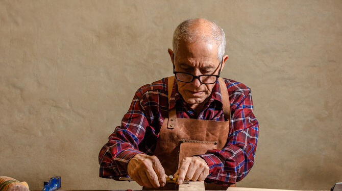 man,senior,old,latin,gray,hair,pensioner,pencil,labor,craft,handicraft,skilled,hammer,wood hammer,clamp,strokes,craftsmen,manual Ein Senior sitzt an einer Werkbank: Für viele Menschen ist es unvorstellbar, nach einem langen Berufsleben plötzlich komplett au