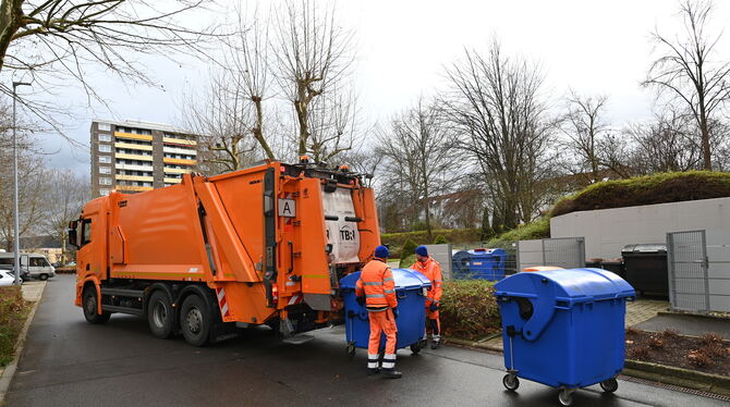 Müllwerker der Technischen Betriebsdienste leeren einen Papiercontainer.