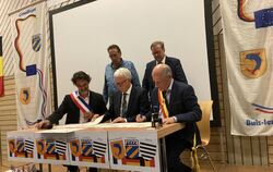 Die drei Bürgermeister Sébastian Bernard (von links), Klemens Betz und Eugéne Wansart unterzeichnen den Partnerschafts- und Freu