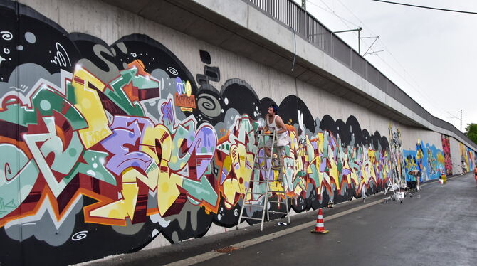 Urbana rt. Fast vollendet: Graffiti-Spayer verwandeln bei »urbana rt.« die Betzinger Bahnmauer in ein buntes Gesamtkunstwerk.
