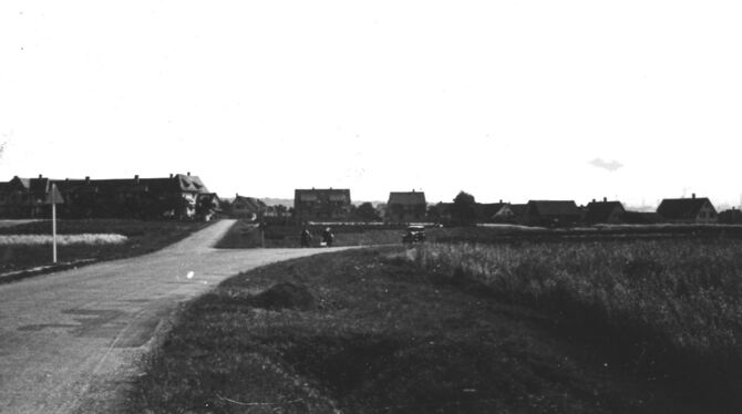1935:  Straßenkreuzung vor einer Siedlung. Um welches Dorf handelt es sich?