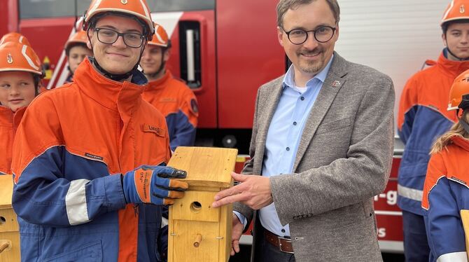 Luca Donatelli, Jugendsprecher der Gomaringer Feuerwehr (links), übergibt hier einen der Nistkästen an Bürgermeister Steffen Heß