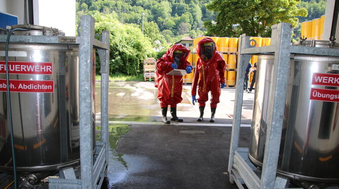 Bad Urach Werksfeuerwehr Sika Übung Ausgerüstet mit Chemikalienschutzanzügen analysieren die Feuerwehrleute zunächst einmal, wie sie mit dem Gefahrstoff umgehen müs