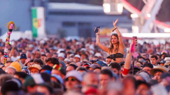 Besucher eines Festivals genießen die Open-Air-Stimmung.