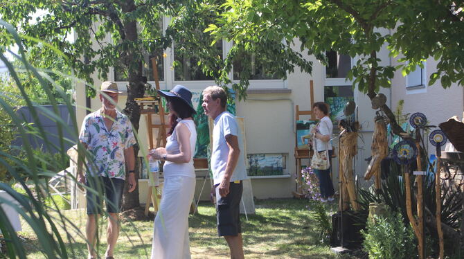 Kunst im Garten von Udo Schmid, Gomaringen Udo Schmid (Mitte) schaut hier Malerin Henriette Striegler über die Schulter. Er bot seinen Garten als Ausstellungsraum an. Rech