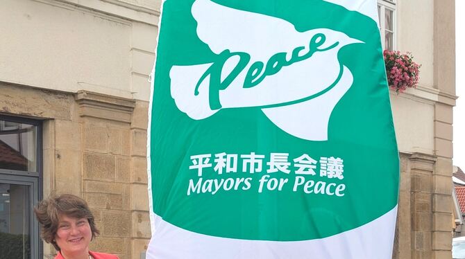 Die Bürgermeisterin Silke Höflinger von Walddorfhäslach hisst am windigen Dienstagmorgen die Flagge des Zusammenschlusses Mayors
