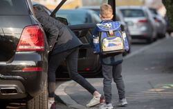 Ein Grundschüler steigt vor der Schule aus Mutters Auto aus. Trauriger Fakt aber ist, dass »Elterntaxis« den Schulweg nicht unbe
