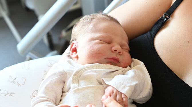 Der kleine Finn schläft friedlich in den Armen seiner Mutter.