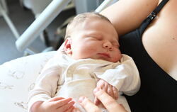 Der kleine Finn schläft friedlich in den Armen seiner Mutter.