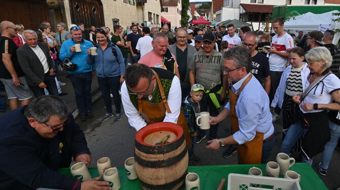 Dorffest Belsen Vereinssprecher Timo Müller schiebt Krüge nach, Tobias Fischer zapft und OB Michael Bulander verteilt Freibier. FOTO: MEYER