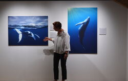Museumsleiterin Dr. Barbara Karwatzki vor zwei Fotografien, die Audun Rikardsen in ihrer arktischen Heimat von Buckelwalen schos