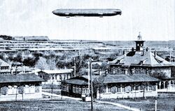 Eine historische Postkarte zeigt den Zeppelin, wie er 1908 über dem Alten Lager schwebte. Eine weitere Postkarte zeigt den Zeppe