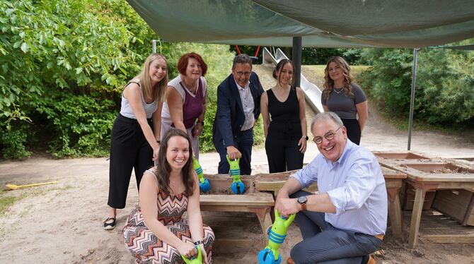 OB Thomas Keck probiert im Garten des Kinderhauses Heinestraße zusammen mit dem Team, Sozialamtsleiter Joachim Haas (Mitte) und