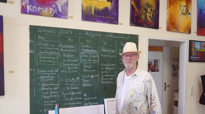 »Schulmeister« Gernot Bizer vor seinem in Kreide gegossenen Stundenplan.