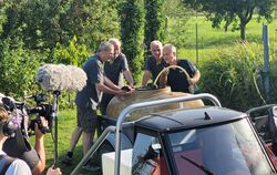 Reiner Gaub, Joachim Funk und Martin Wörnle (von links nach rechts) befüllen zusammen mit SWR-Reporter Harry Röhrle das Wasserfa
