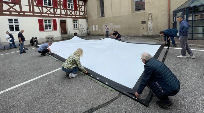 Helfer bauen am Montag im Reutlinger Spitalhof die Großleinwand ab.