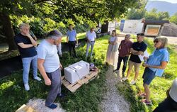 Planorama-Chef Maik Böhmer (2. von links) zeigt Mitgliedern des Gartenbau-Ausschusses einen Stein, der im neuen Kurpark als Sitz
