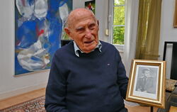 Josef Szajowski mit einem Foto, das ihn mit Mitte 20 zeigt. Das war kurz nach dem Ende des Zweiten Weltkriegs. Diesen hatte der 
