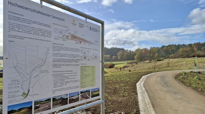 Hochwasserrückhaltebecken Hochwasserschutz Sonnenbühl Erpfingen Damm Ein Hinweisschild informiert über Funktion und technische Daten des Hochwasserrückhaltebeckens.